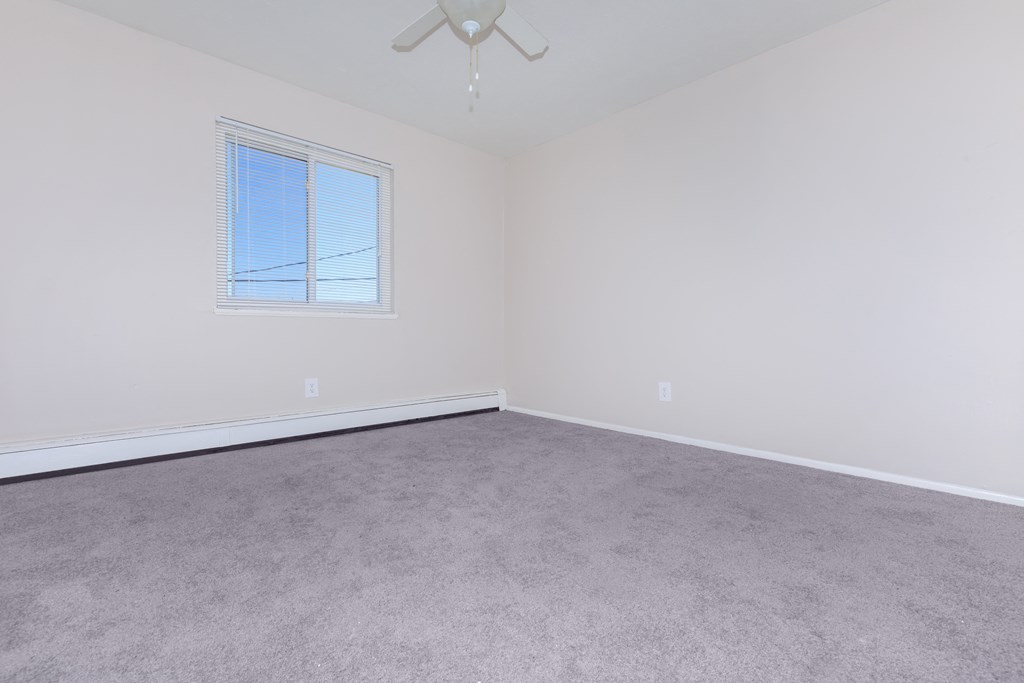 a bedroom with white walls and carpet