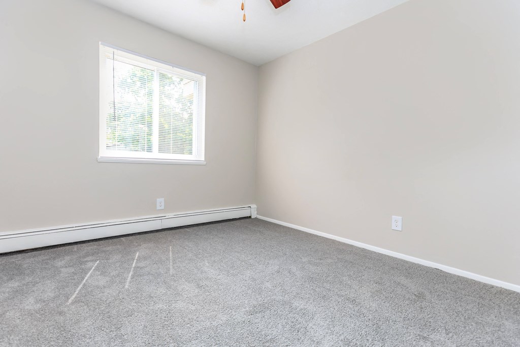 a bedroom with gray walls and a white window