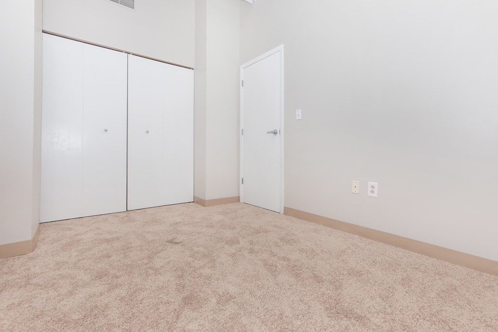 a room with carpet and white walls and doors