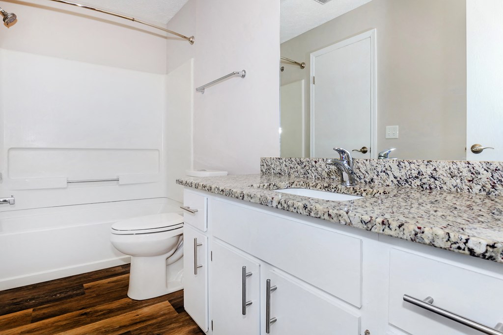 a bathroom with white cabinets and a white toilet