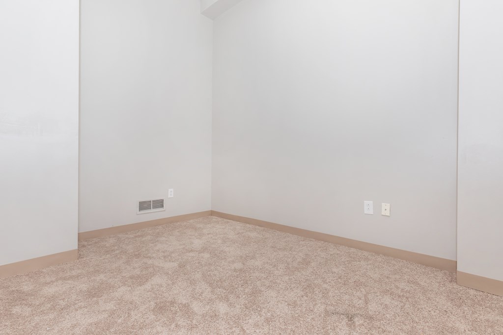 an empty room with a carpeted floor and white walls