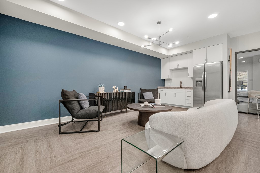 A modern living room with a glass coffee table and a white chair. at Park Lamont Townhomes Apartments, Cleveland, OH, 44106