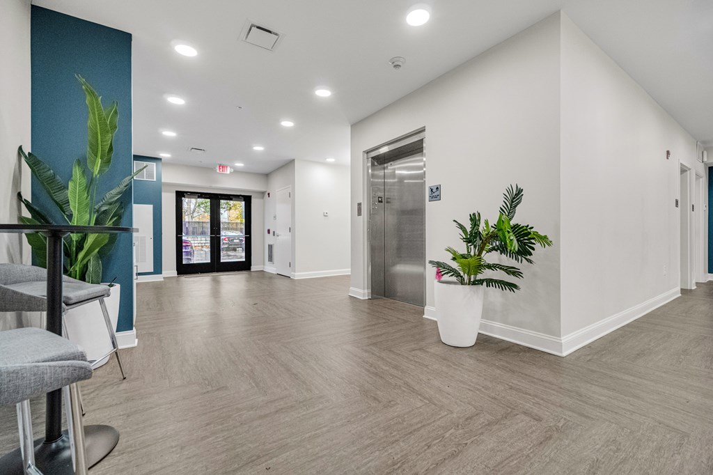 A room with a grey chair and a plant in a white pot. at Park Lamont Townhomes Apartments, Cleveland 44106