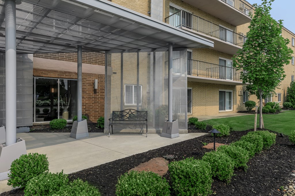a bench under an awning in front of a brick building