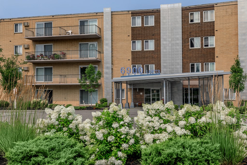 a large brick building with white flowers in front of it