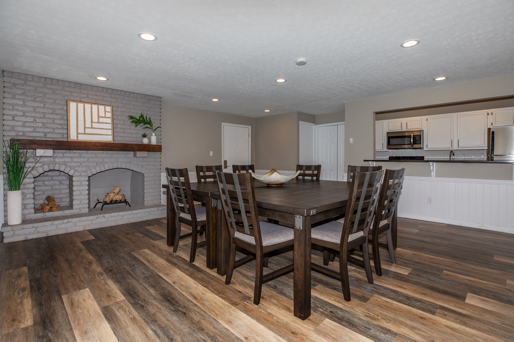 a dining room with a table and chairs in front of a fireplace