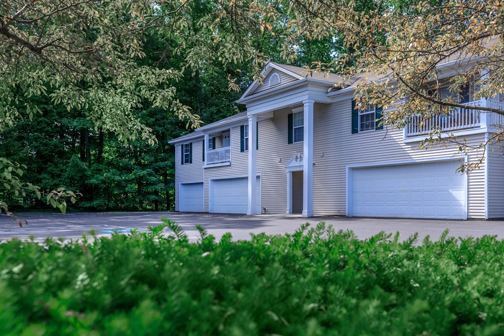 a house with two garages and trees in the background