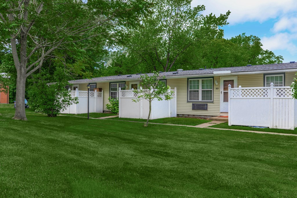 a mobile home with a white fence and green grass