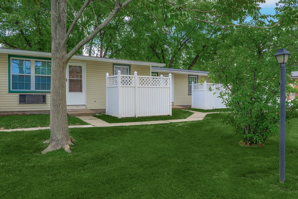 a white picket fence in front of a yellow house