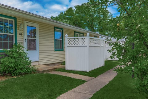 a white fence in front of an apartment