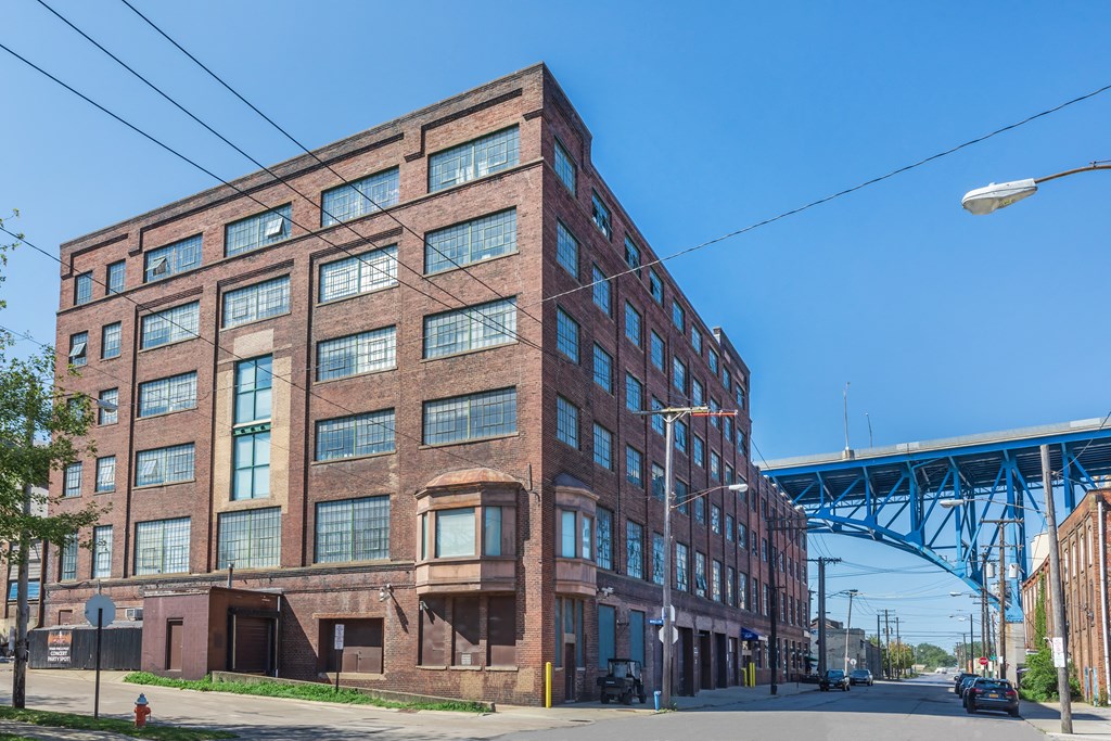 a large brick building with a bridge in the background