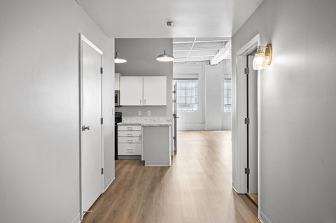 A kitchen with white cabinets and a wooden floor.