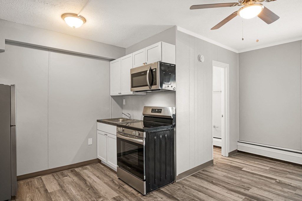 a kitchen with a stove and a microwave and a ceiling fan