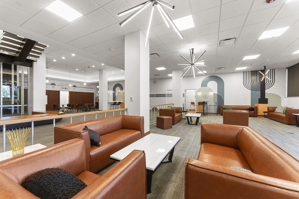 A modern office space with brown leather couches and a white ceiling.