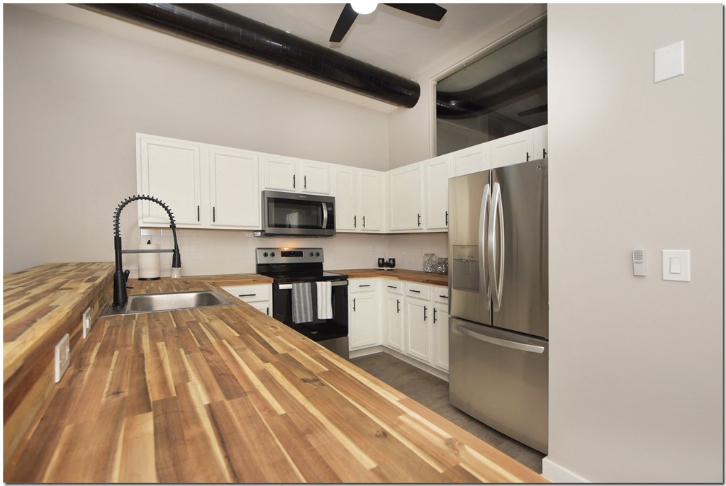 a kitchen with wood flooring and stainless steel appliances