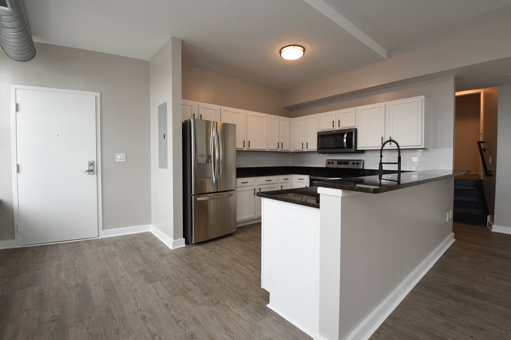 a kitchen with white cabinets and stainless steel appliances