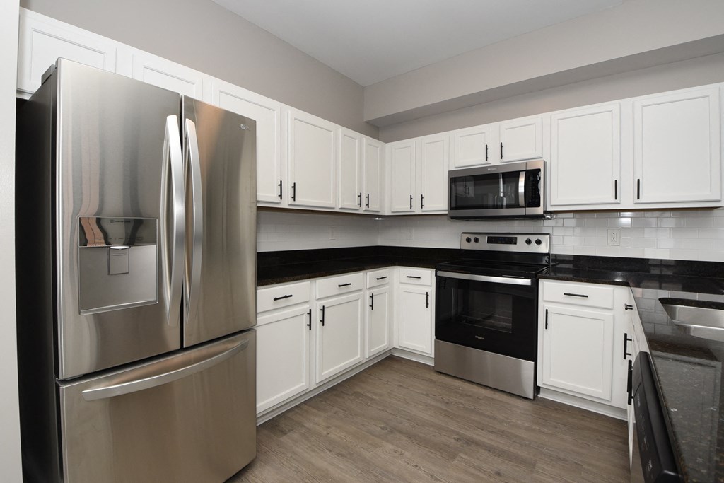 a kitchen with stainless steel appliances and white cabinets