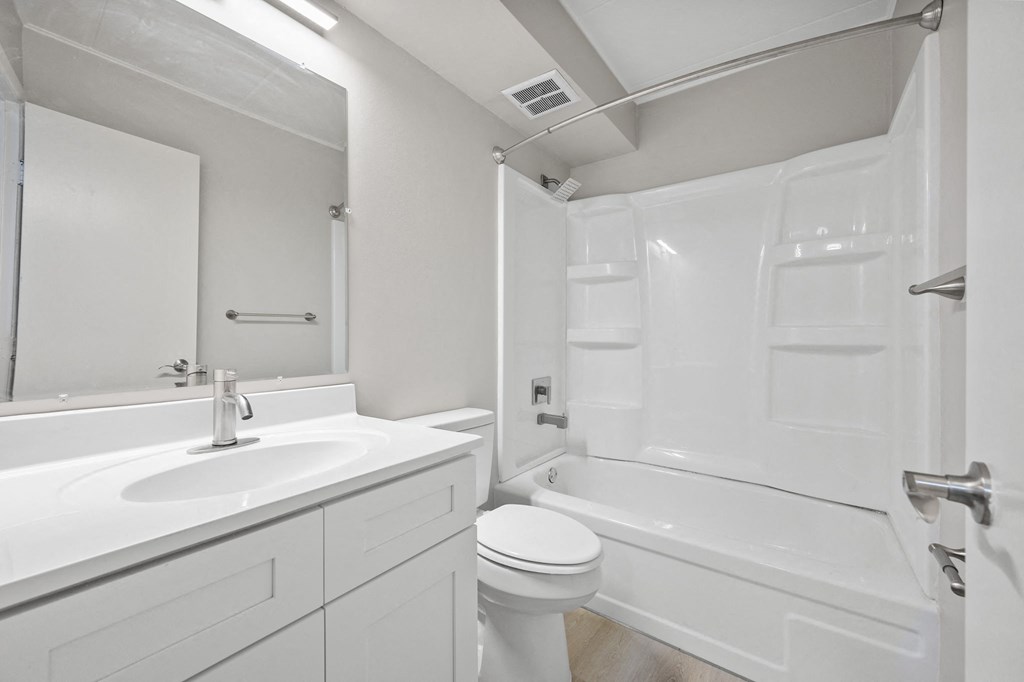 a white bathroom with a sink toilet and shower