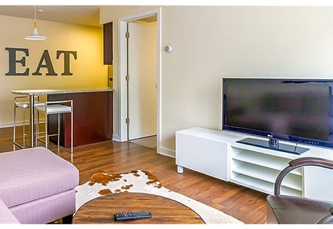A living room with a television and a purple chair.