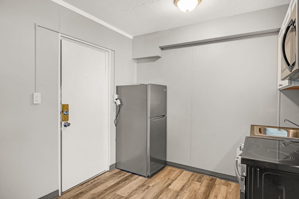 a kitchen with a refrigerator and a stove and a door