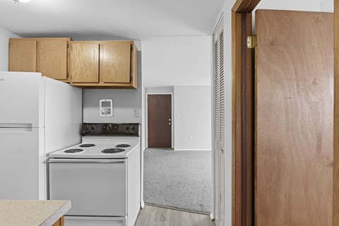 A kitchen with a white refrigerator and a white stove top oven.