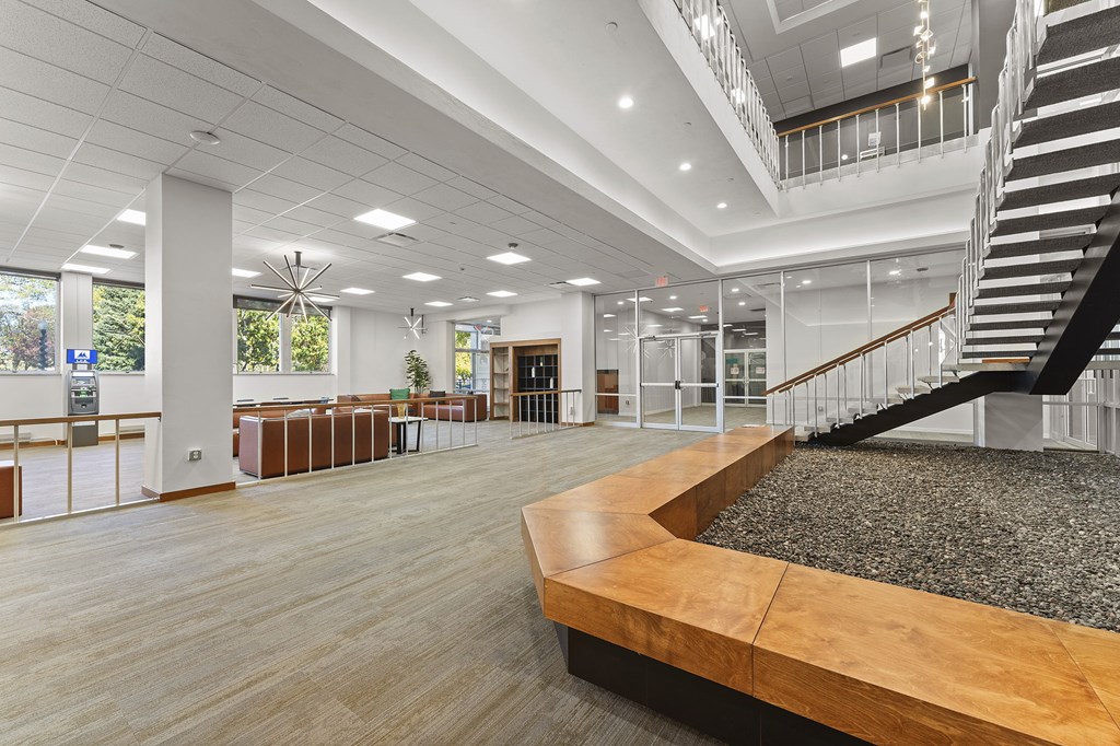 A spacious interior with a staircase, tables, and chairs.