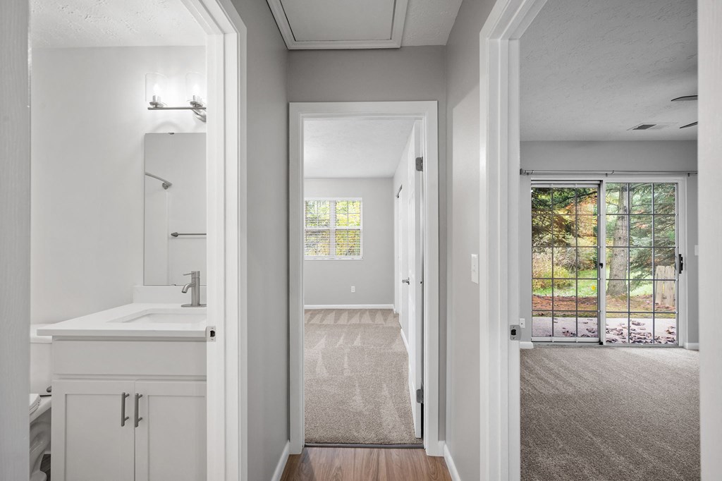 an open bathroom with a view of a bedroom and a door to a yard