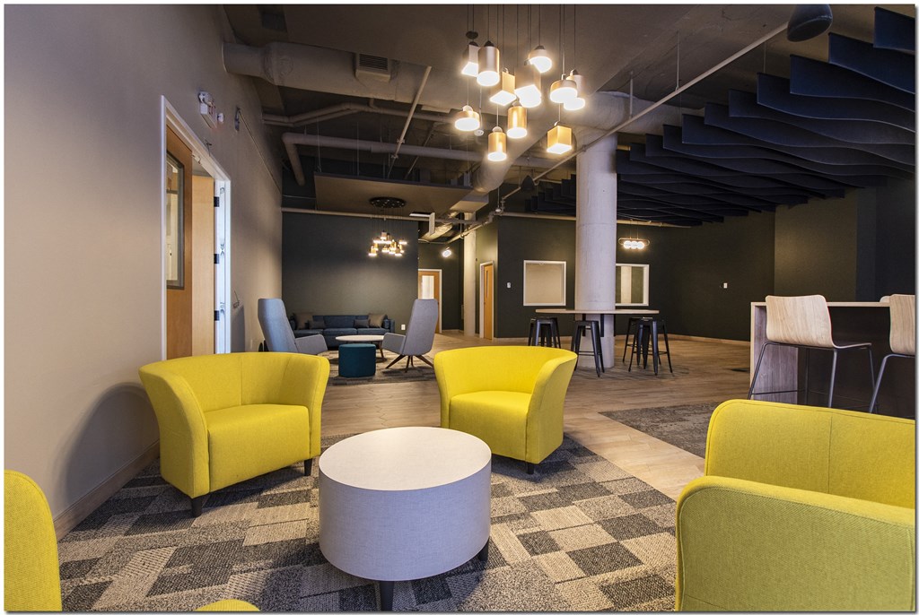 a large room with yellow chairs and grey chairs