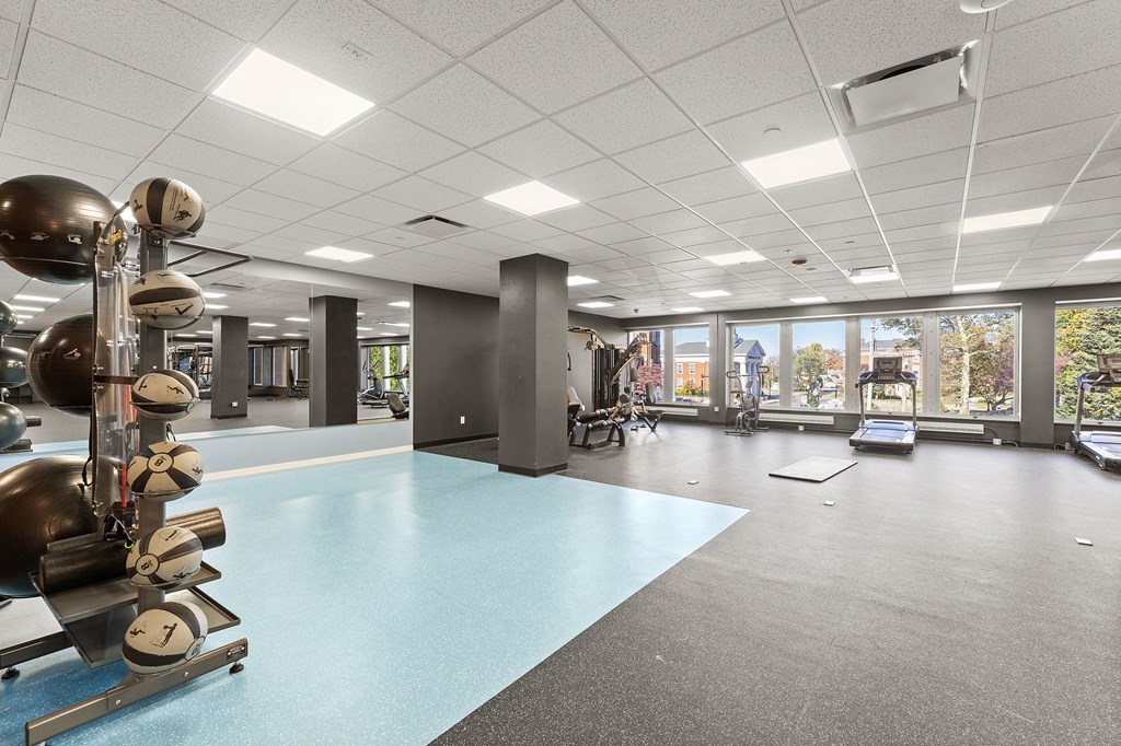 A gym with a blue floor and various exercise equipment.