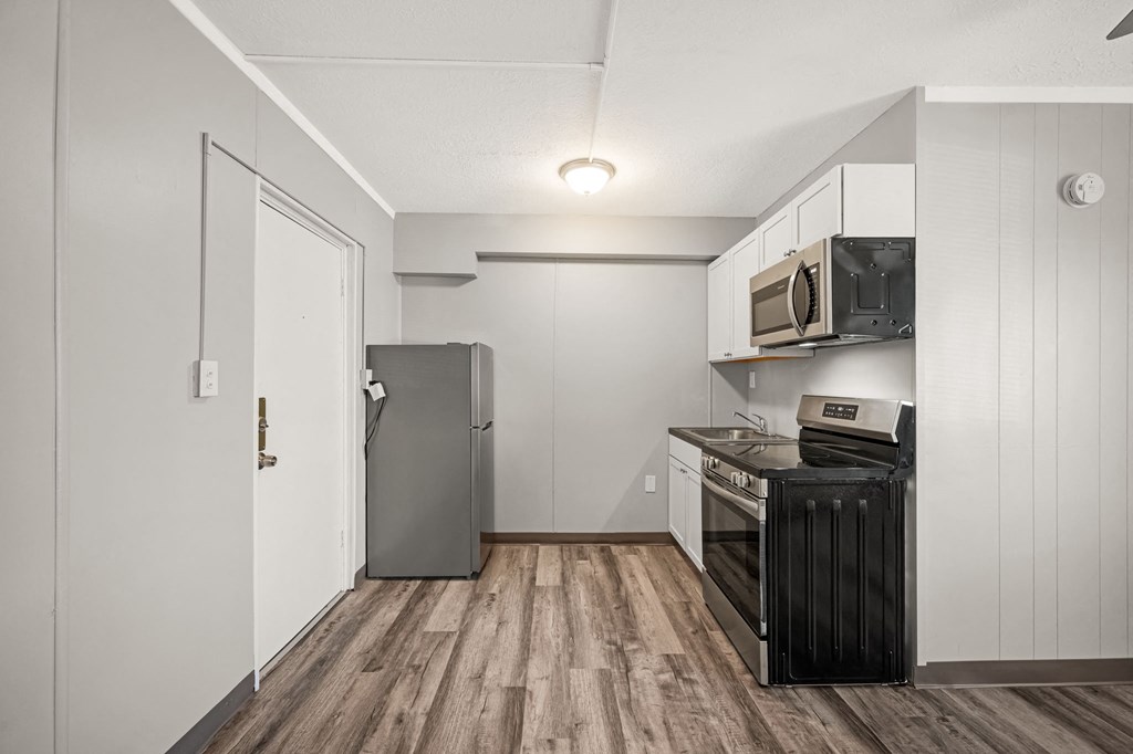 a kitchen with white cabinets and a black stove and refrigerator