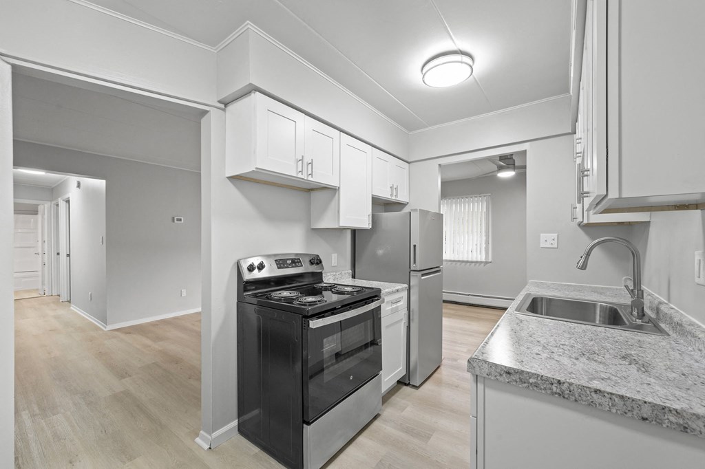 a renovated kitchen with white cabinets and black appliances