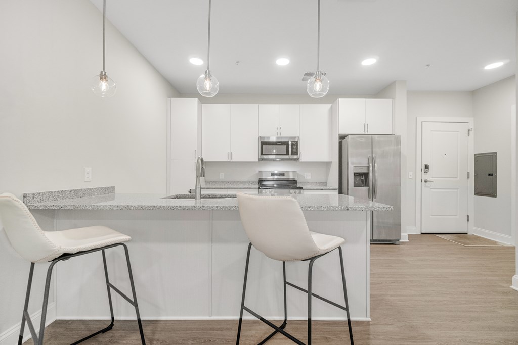 A kitchen with white cabinets and a marble countertop. at Park Lamont Townhomes Apartments, Cleveland