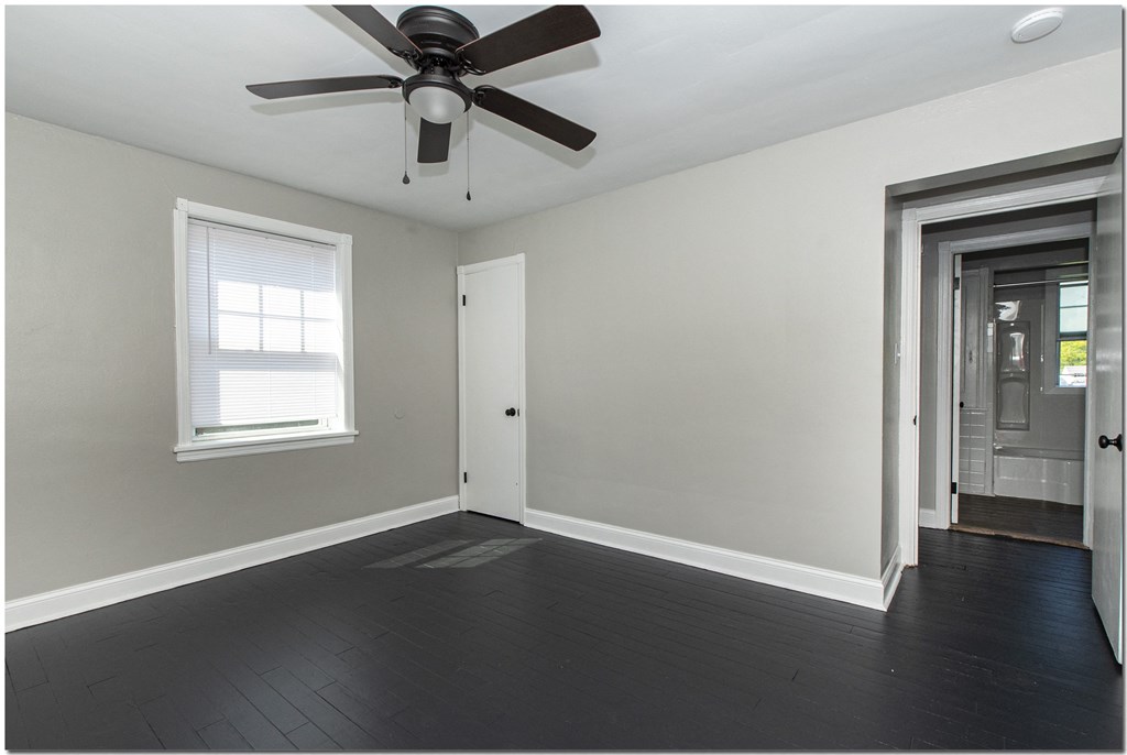 a bedroom in an empty house with a ceiling fan