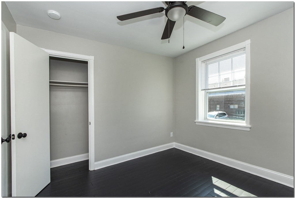 a bedroom with a closet and a ceiling fan