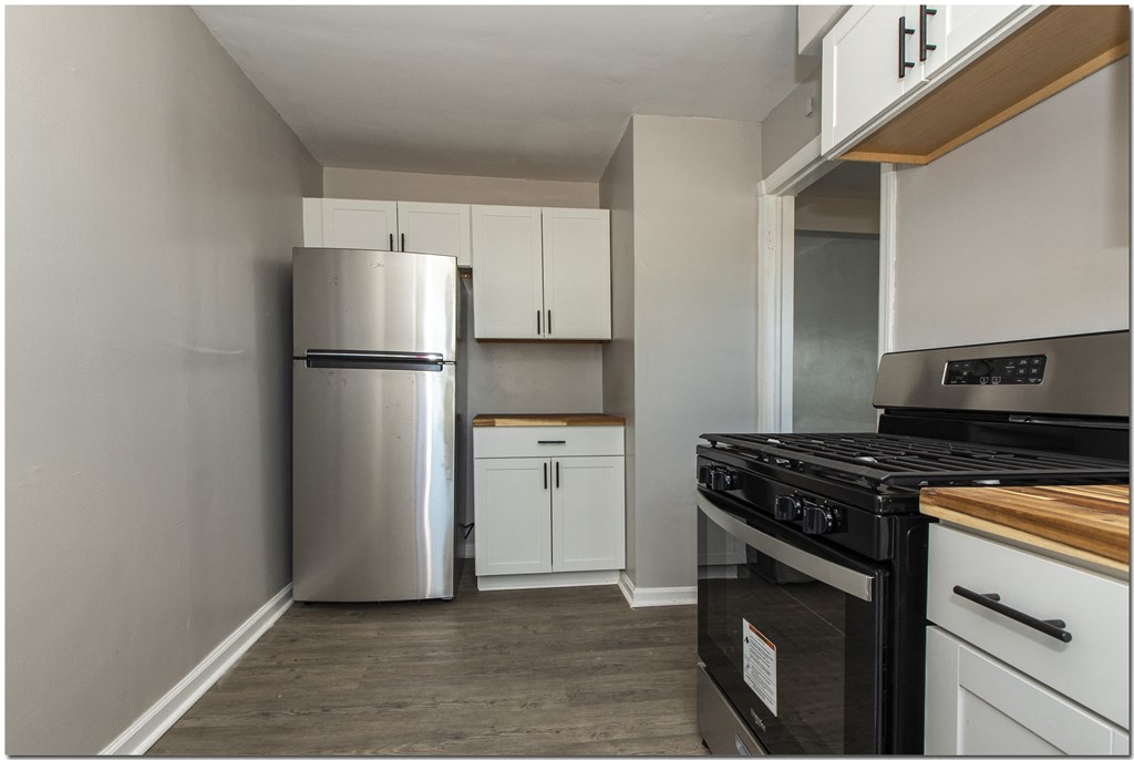 a kitchen with a stove refrigerator and cabinets