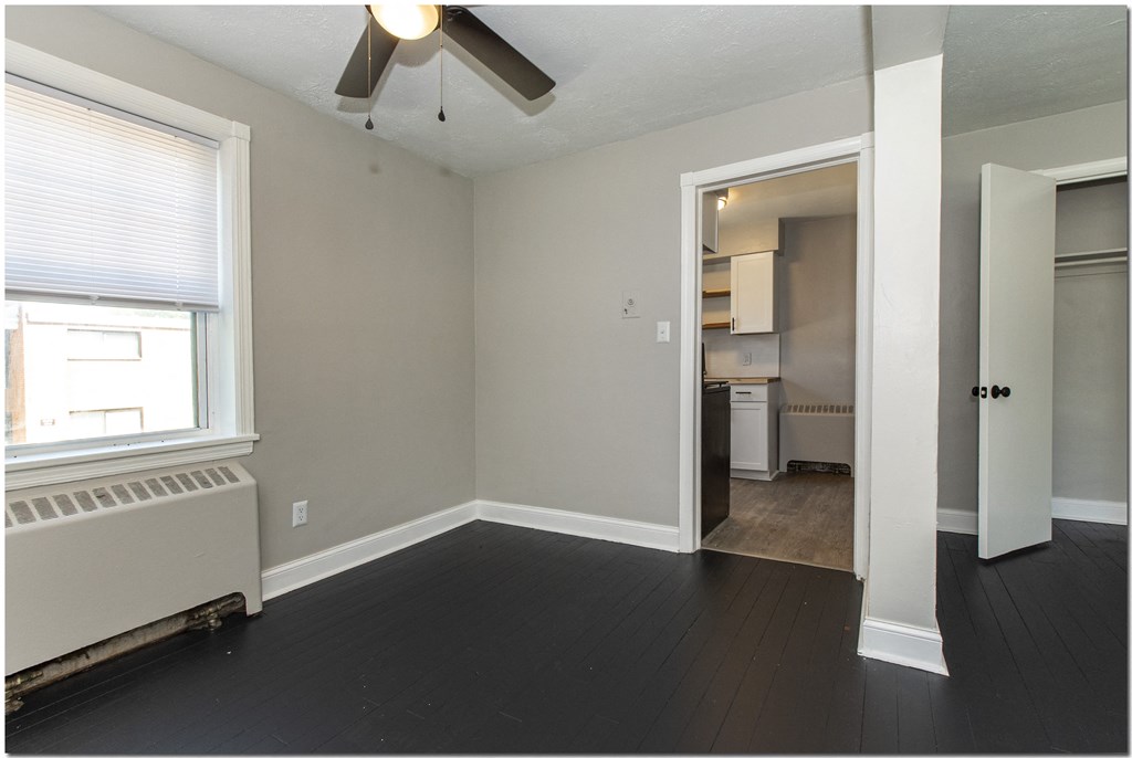 a bedroom with a ceiling fan and a radiator