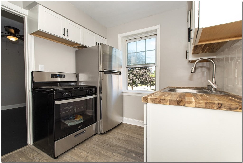 a kitchen with white cabinets and stainless steel appliances