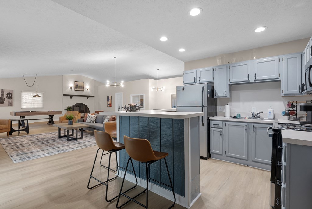 A kitchen with a bar area and chairs.