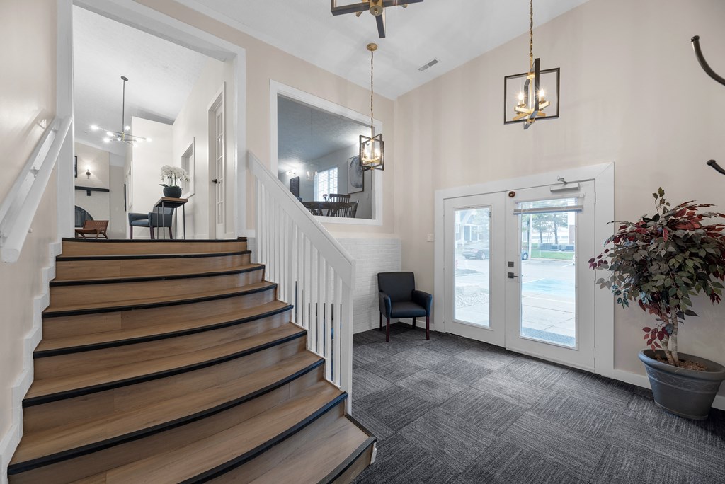 A house interior with a staircase and a potted plant.