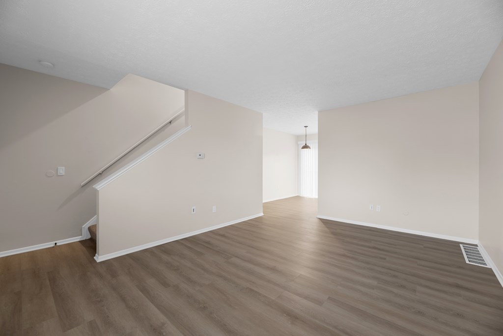 A room with wooden flooring and a staircase.