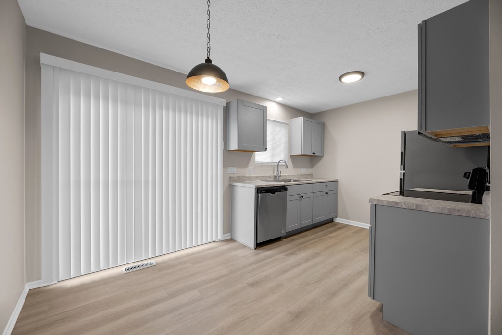 A kitchen with a white countertop and grey cabinets.