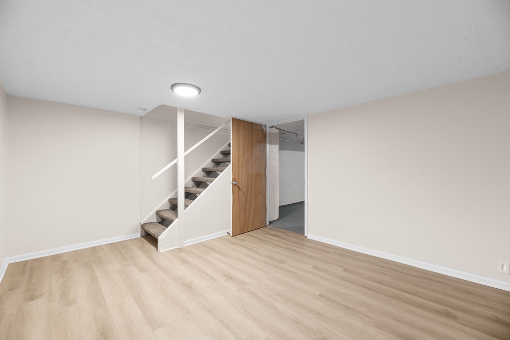 A room with a wooden staircase and a white wall.