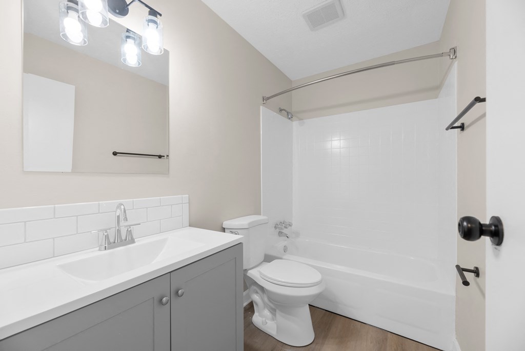 A white toilet sits next to a sink in a bathroom.