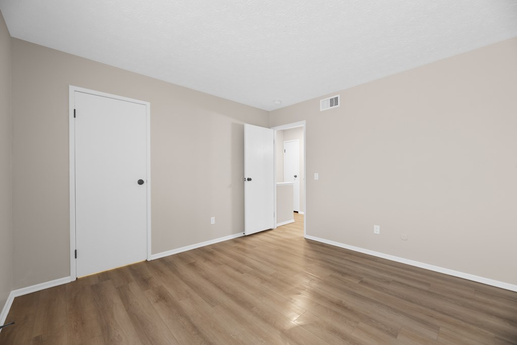 A room with wooden floors and two white doors.