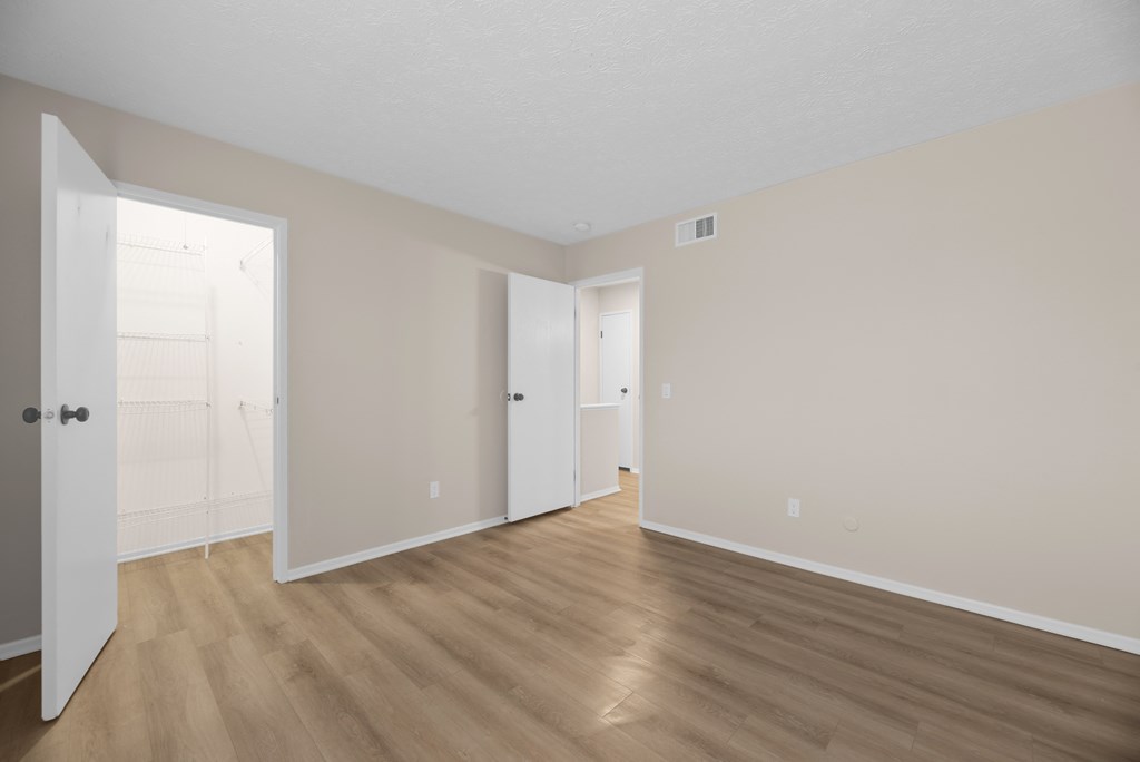 A room with wooden floors and white doors.