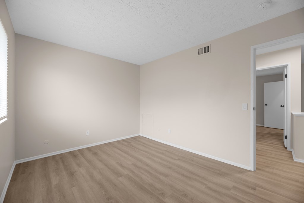 A room with light colored walls and wood flooring.