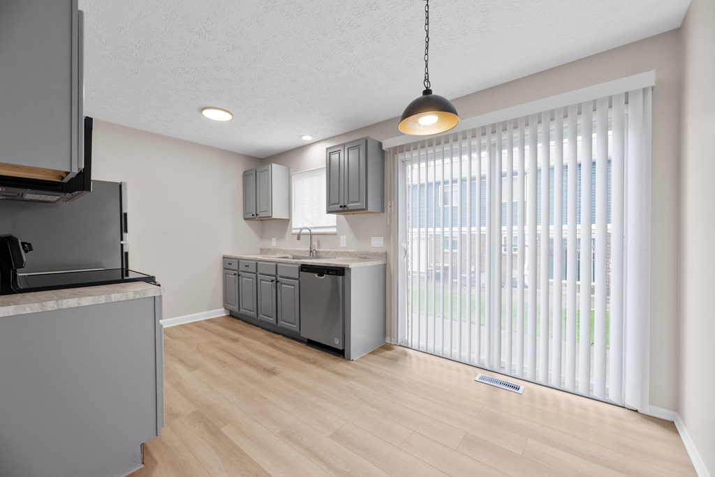 A modern kitchen with wooden floors and white walls.