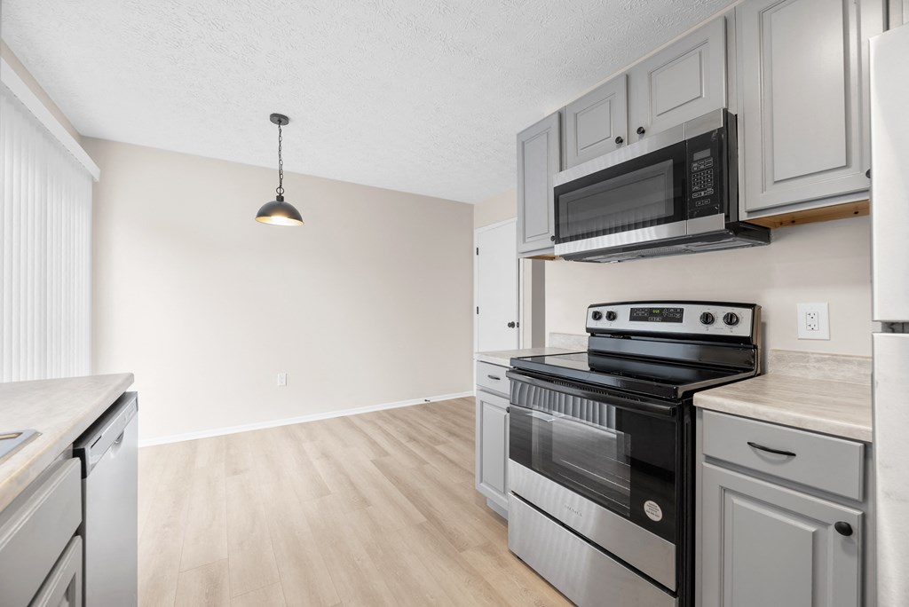 A kitchen with a stove, oven, and microwave.