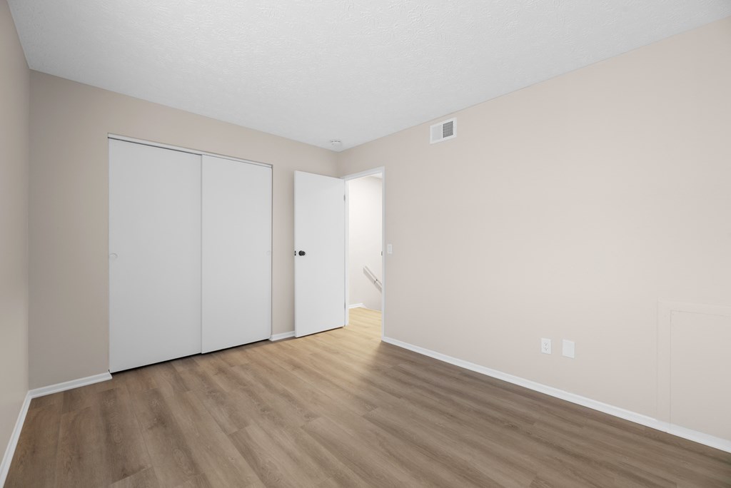 A room with a white door and a white closet.