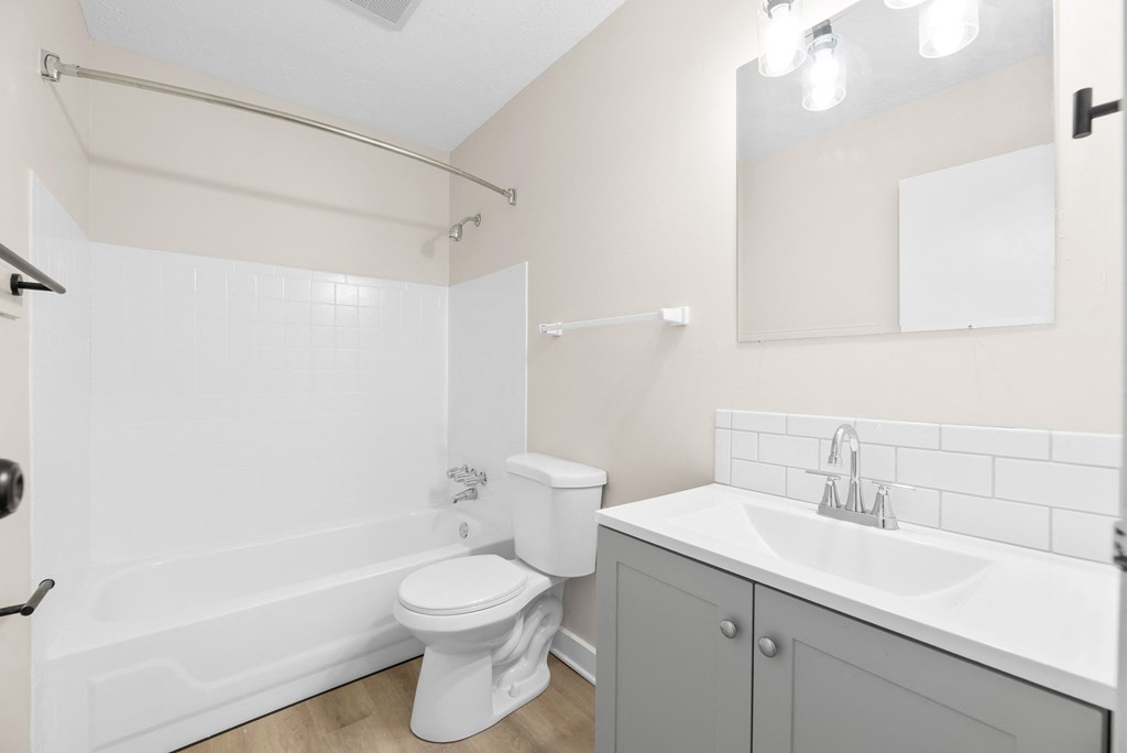 A white toilet sits next to a white sink in a bathroom.